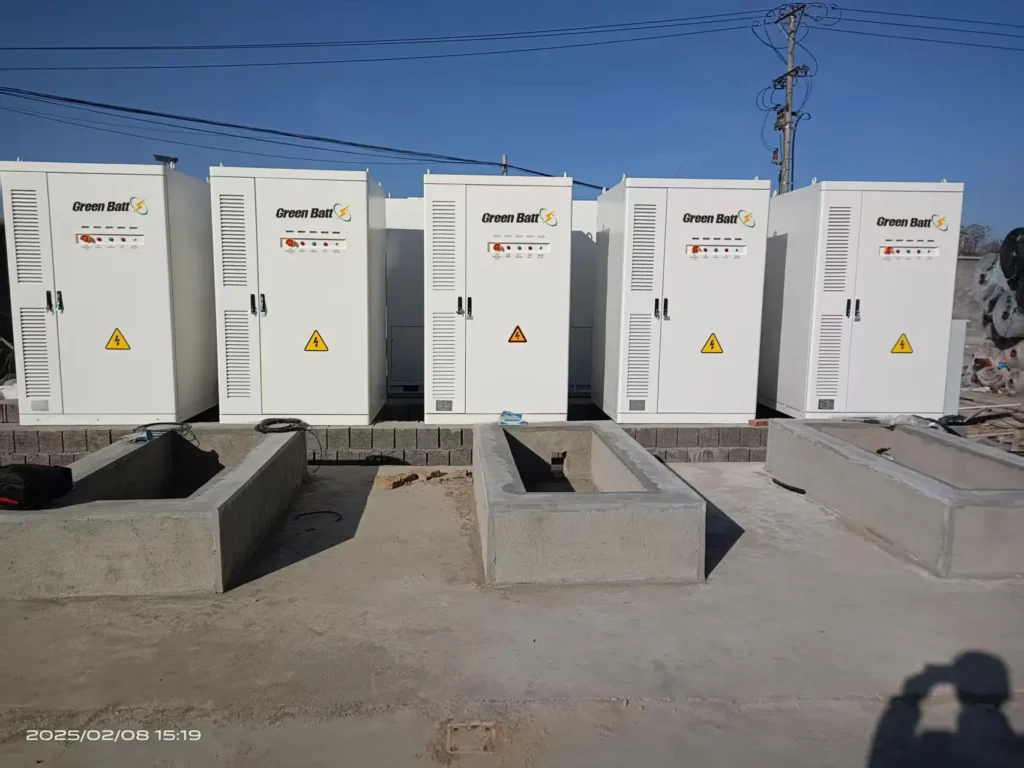Professional installation of GreenBatt Smart ESS All-In-One commercial energy storage systems, showing multiple liquid-cooled battery cabinets with green housings deployed in an industrial facility.